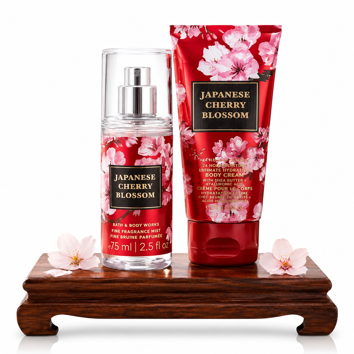 Bath & Body Works Japanese Cherry Blossom Mini set con body mist 75ml en frasco transparente con diseño de flores de cerezo rojas y rosas y crema corporal 70g en tubo rojo con flores de cerezo, sobre base de madera con flores de cerezo reales