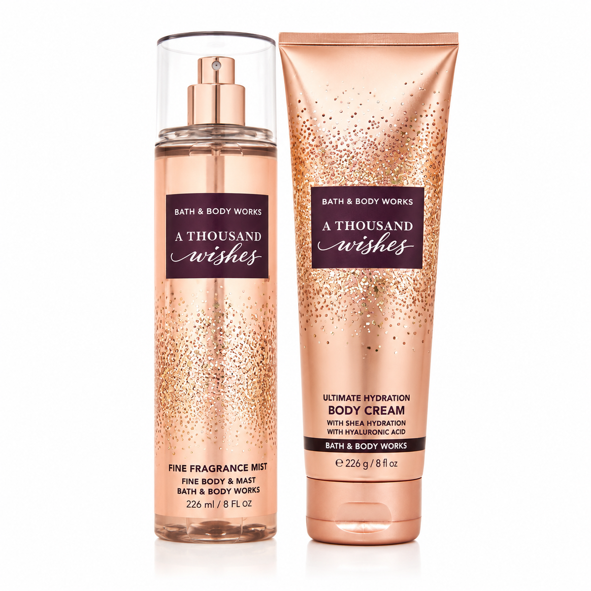 Bath & Body Works A Thousand Wishes set con body mist 226ml en frasco transparente con detalles dorados y brillantes y crema corporal 226g en tubo dorado rose gold con diseño de purpurina, fondo blanco